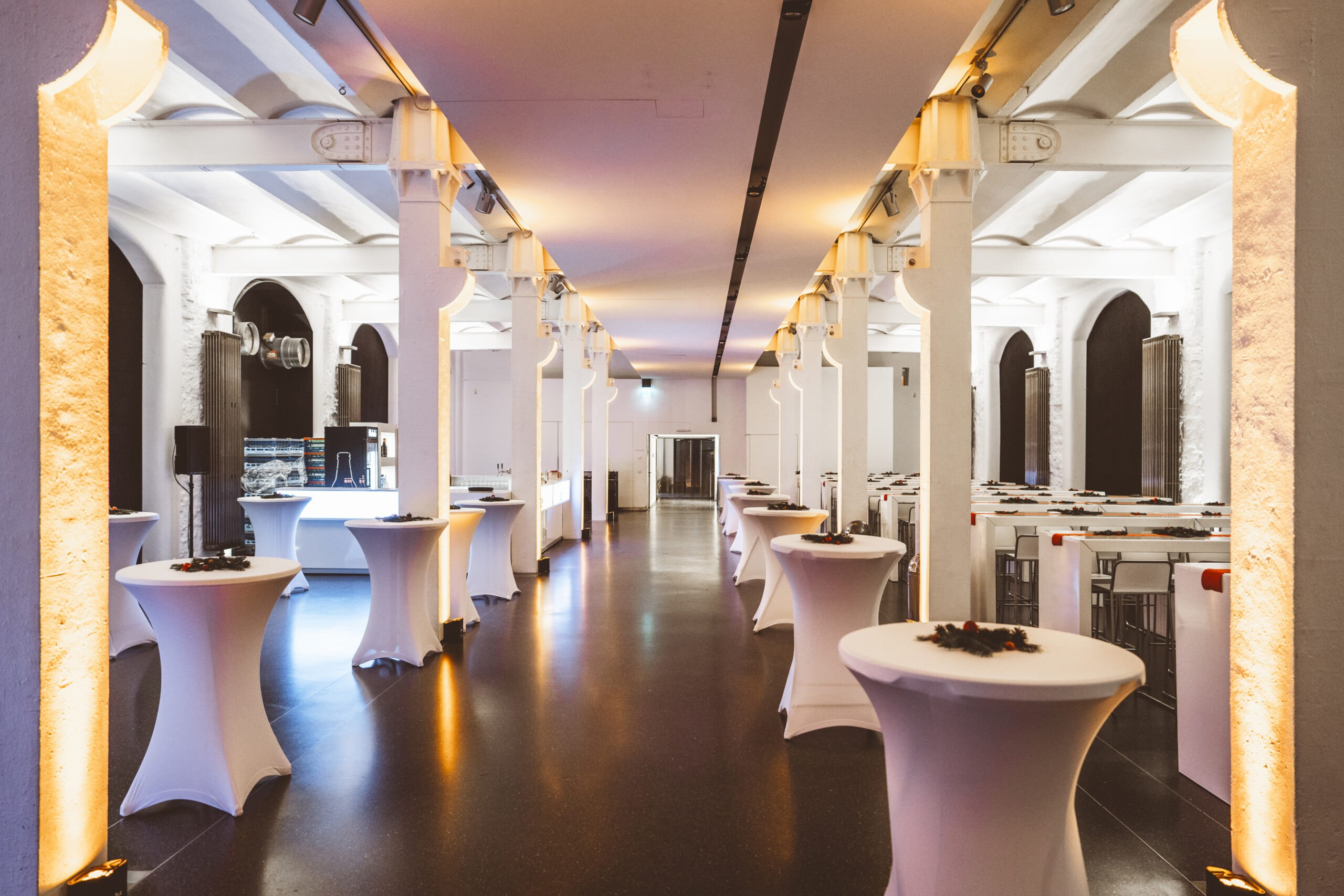 Eine Halle mit Stehtischen und einer Bar | Event Catering von Kaiserwetter